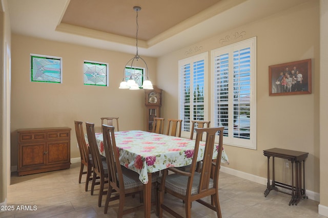 dining room with a raised ceiling and a notable chandelier