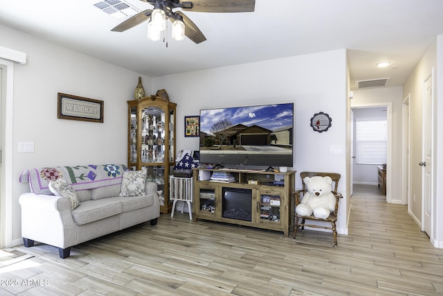 living room featuring ceiling fan and light wood-type flooring