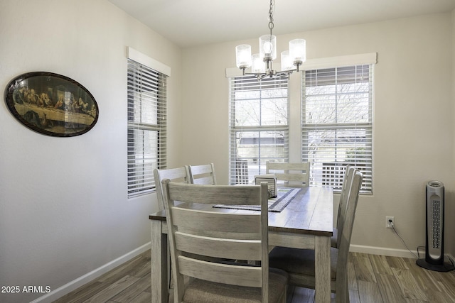 dining room featuring dark wood-type flooring and a notable chandelier