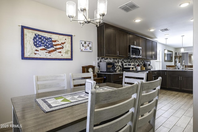 dining area with an inviting chandelier and sink