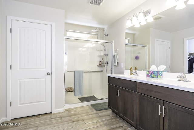 bathroom featuring walk in shower and vanity