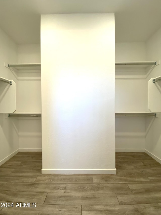 walk in closet with hardwood / wood-style flooring