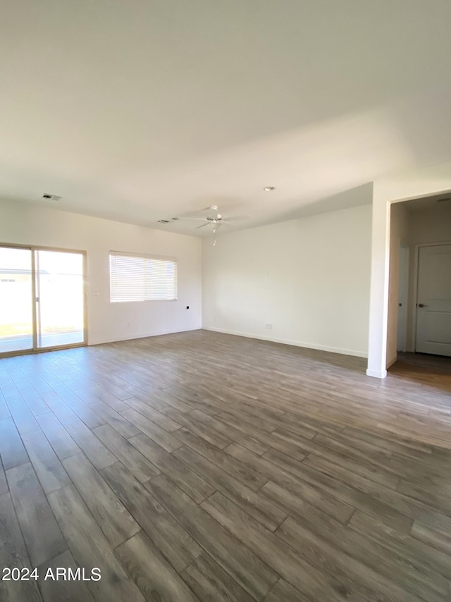 empty room with ceiling fan and dark hardwood / wood-style flooring