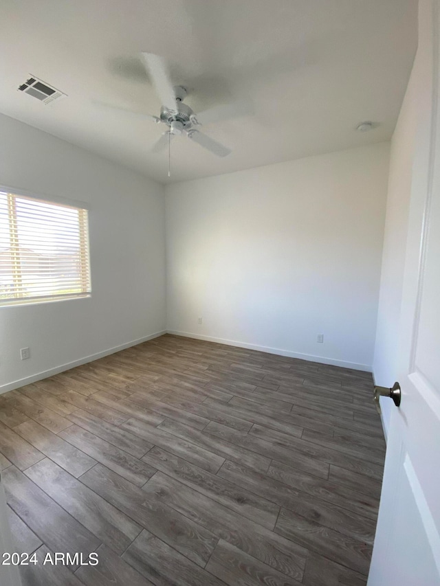 empty room with dark hardwood / wood-style floors and ceiling fan