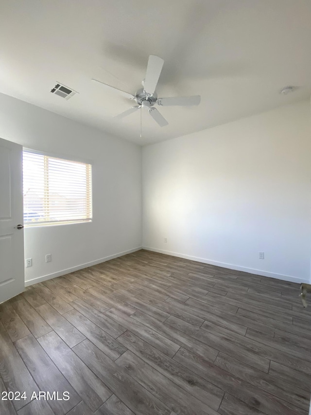 spare room featuring ceiling fan and dark hardwood / wood-style floors