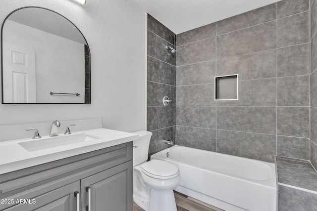 full bathroom featuring vanity, toilet, tiled shower / bath combo, and wood-type flooring