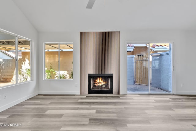 unfurnished living room with lofted ceiling, light hardwood / wood-style floors, and ceiling fan