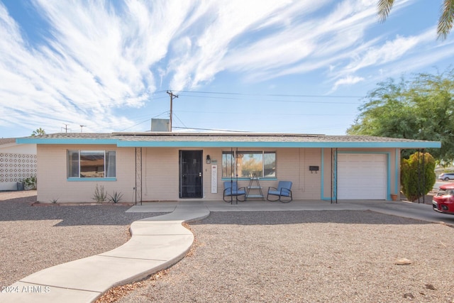 single story home featuring a porch and a garage