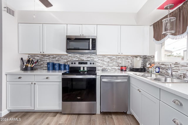 kitchen featuring sink, white cabinets, stainless steel appliances, and light wood-type flooring