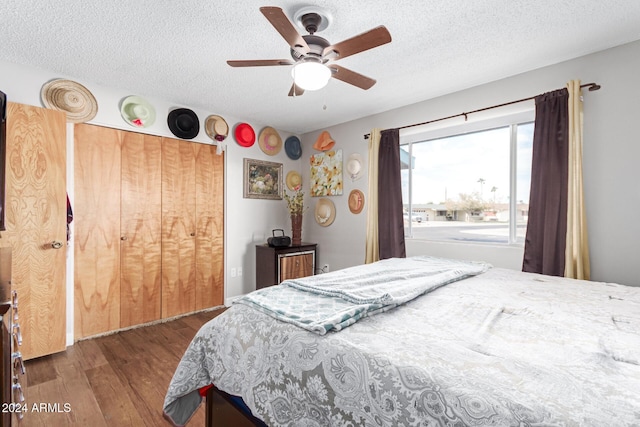 bedroom featuring a textured ceiling, ceiling fan, and dark wood-type flooring