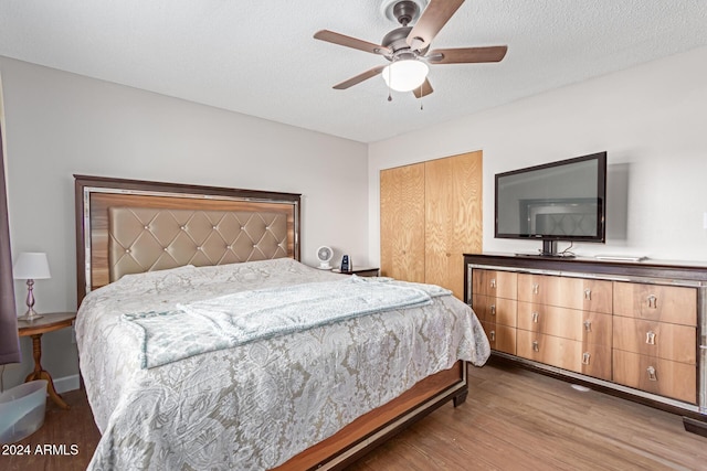 bedroom featuring ceiling fan, a closet, a textured ceiling, and hardwood / wood-style flooring