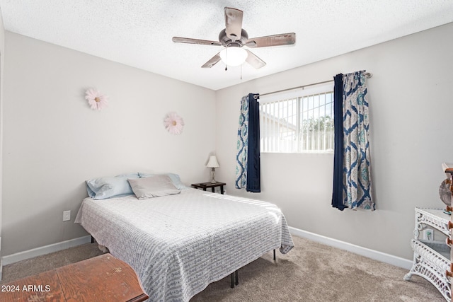 bedroom with ceiling fan, carpet floors, and a textured ceiling