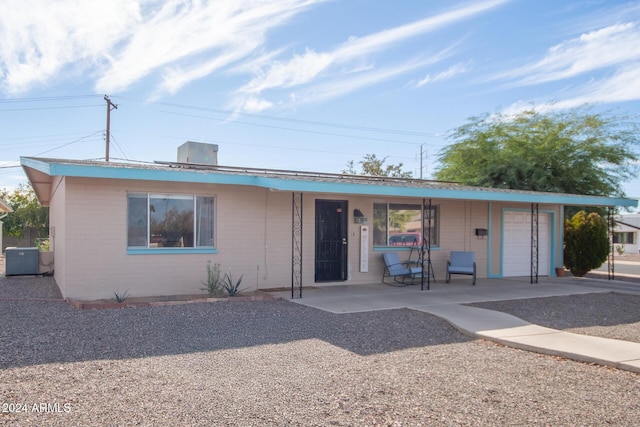 ranch-style house with central AC unit and a garage