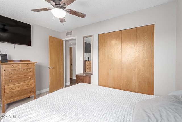 bedroom with ceiling fan, a closet, and a textured ceiling