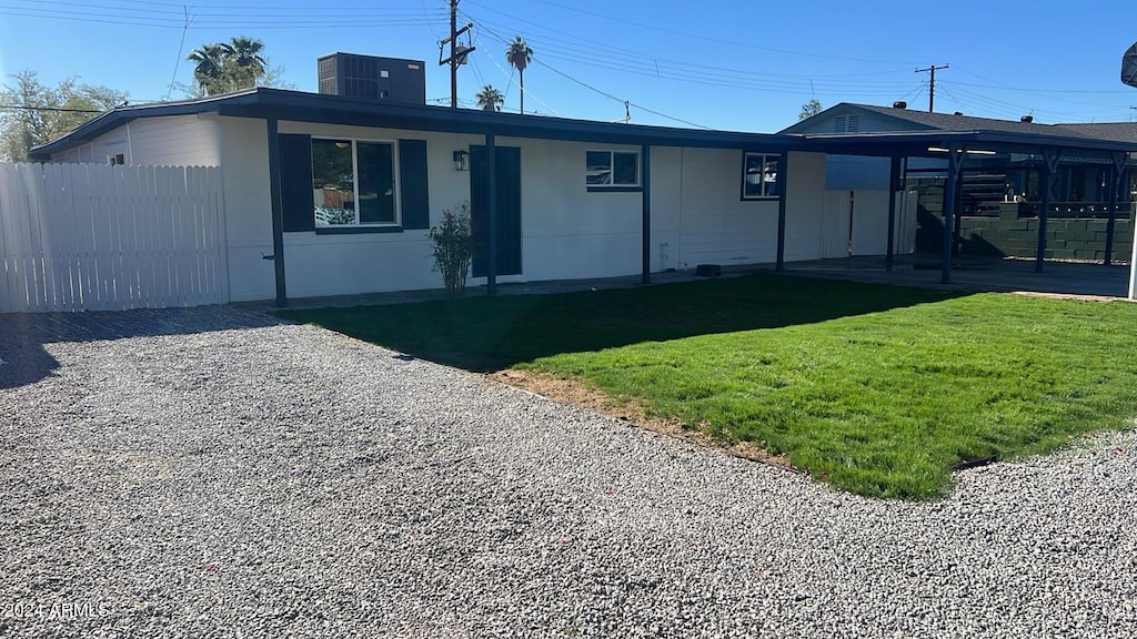 view of front facade with a front yard and central AC unit