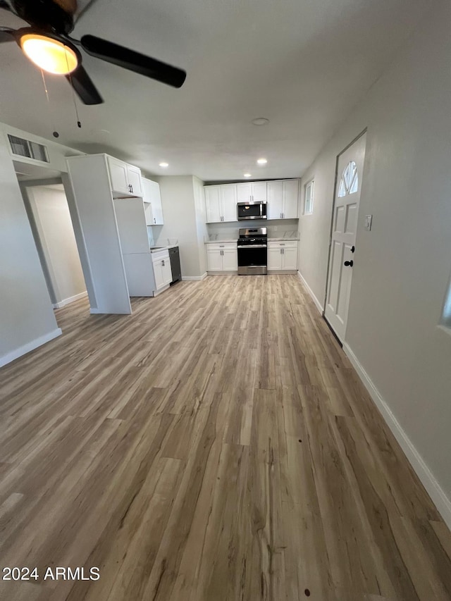 unfurnished living room with ceiling fan and light hardwood / wood-style floors