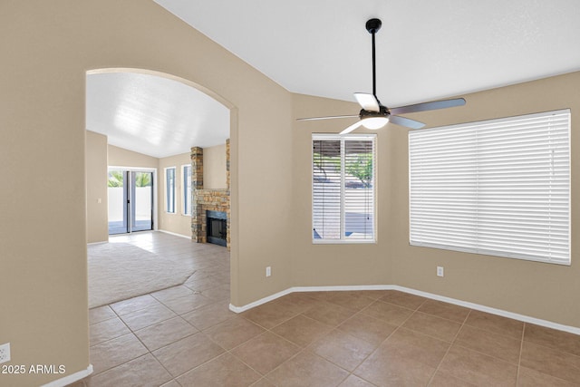 5252 W Pontiac Dr, Glendale, AZ 85308 - unfurnished dining area featuring light tile patterned floors, baseboards, ceiling fan, a fireplace, and vaulted ceiling