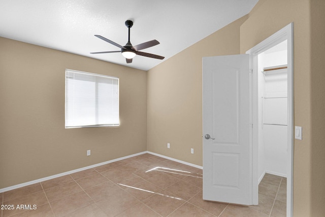 5252 W Pontiac Dr, Glendale, AZ 85308 - empty room with light tile patterned floors, ceiling fan, vaulted ceiling, and baseboards