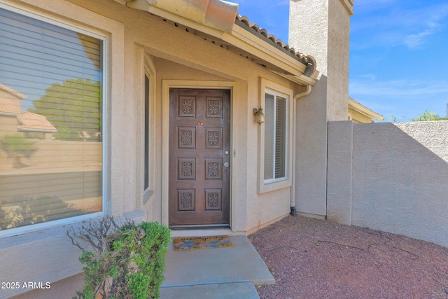 5252 W Pontiac Dr, Glendale, AZ 85308 - doorway to property featuring a chimney, stucco siding, and fence