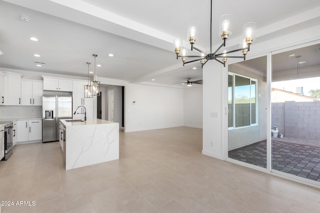 kitchen with ceiling fan with notable chandelier, a center island with sink, white cabinets, pendant lighting, and appliances with stainless steel finishes