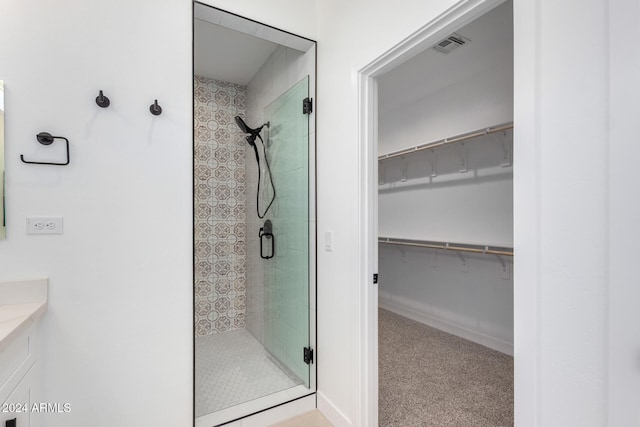 bathroom with vanity and a shower with door