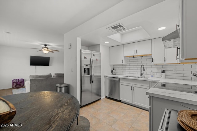 6008 W Augusta Ave, Glendale, AZ 85301 - kitchen with appliances with stainless steel finishes, tasteful backsplash, wall chimney range hood, ceiling fan, and open floor plan