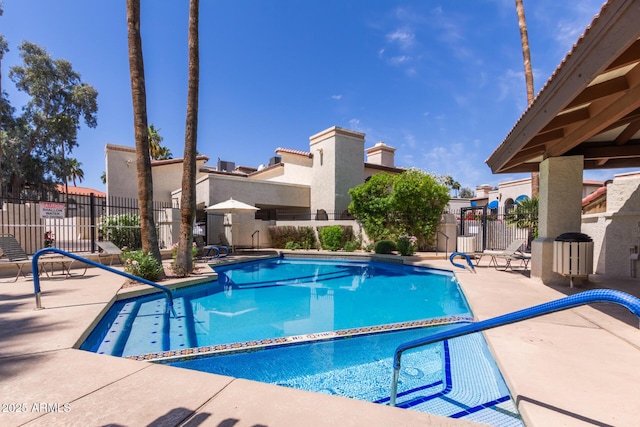 community pool featuring fence and a patio area