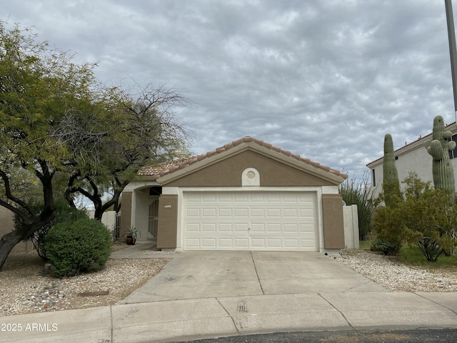 view of front of home featuring stucco siding, concrete driveway, a tile roof, and an attached garage