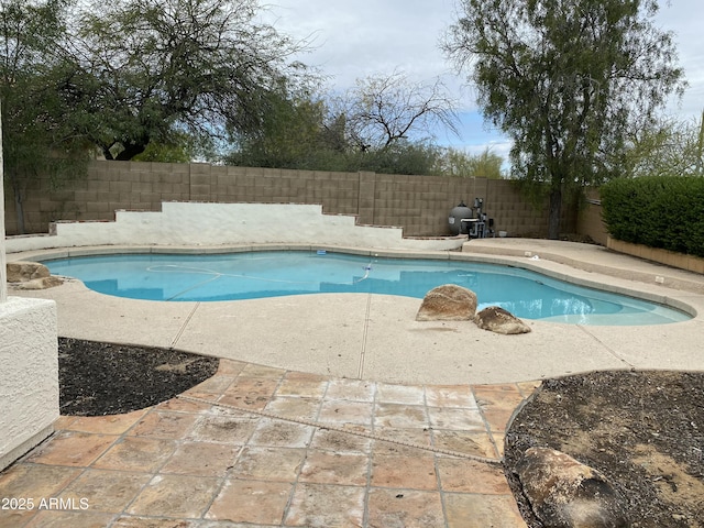 view of pool with a fenced in pool, a fenced backyard, and a patio area