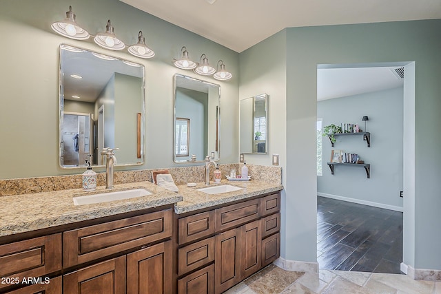 402 E Claremont St, Phoenix, AZ 85012 - bathroom featuring double vanity, baseboards, and wood finished floors
