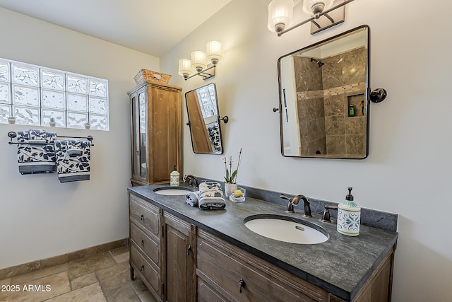 402 E Claremont St, Phoenix, AZ 85012 - full bath featuring double vanity, baseboards, stone tile floors, and a tile shower