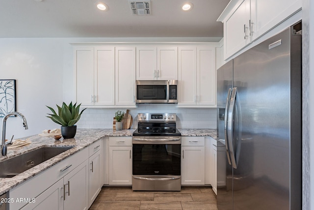 9835 E Wavelength Ave, Mesa, AZ 85212 - kitchen with white cabinets, visible vents, a sink, stainless steel appliances, and decorative backsplash