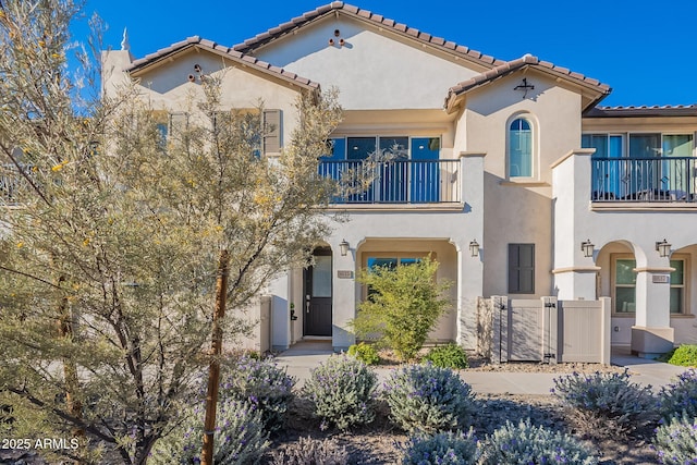 9835 E Wavelength Ave, Mesa, AZ 85212 - mediterranean / spanish-style house featuring a gate, stucco siding, a tile roof, and a balcony