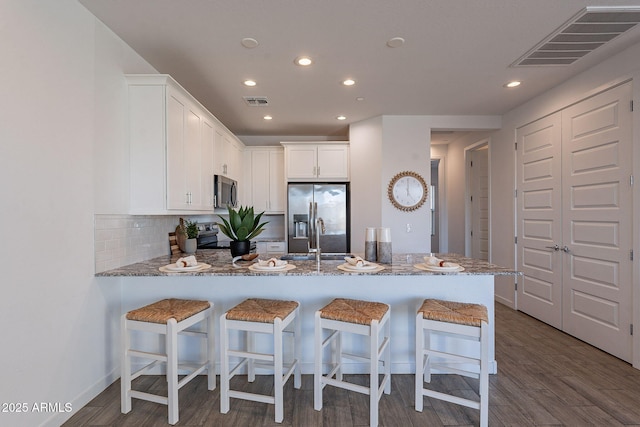 9835 E Wavelength Ave, Mesa, AZ 85212 - kitchen featuring a peninsula, white cabinets, visible vents, appliances with stainless steel finishes, and a sink