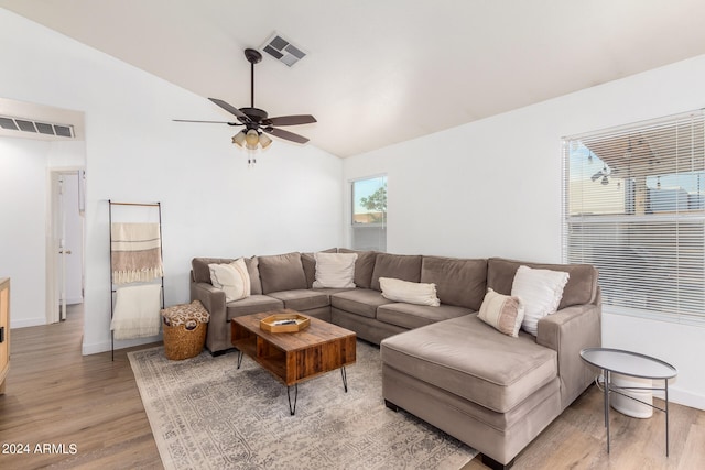 living room with ceiling fan, lofted ceiling, and light wood-type flooring