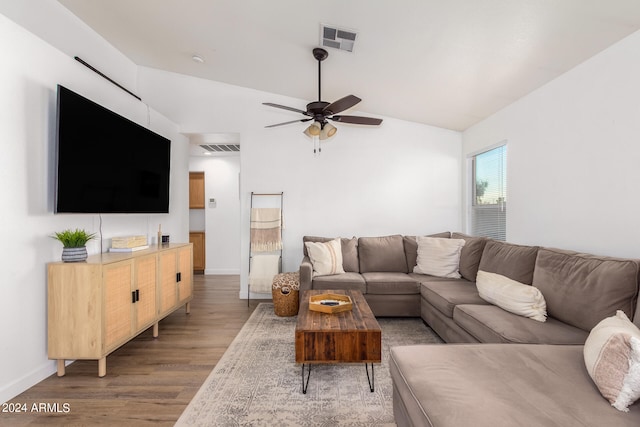 living room with ceiling fan, hardwood / wood-style flooring, and vaulted ceiling