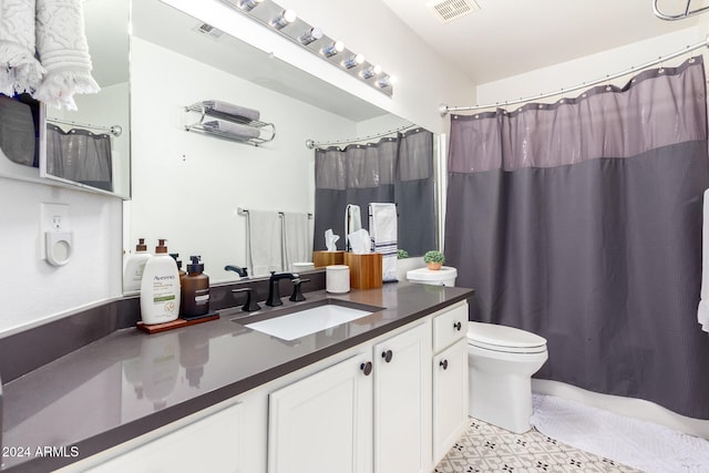 bathroom featuring vanity, curtained shower, and toilet