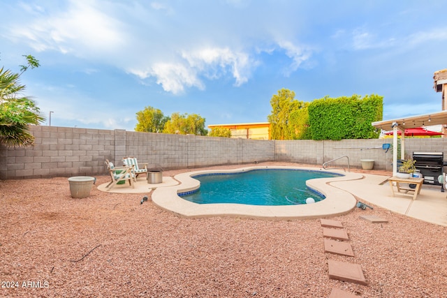 view of swimming pool featuring a patio and a grill