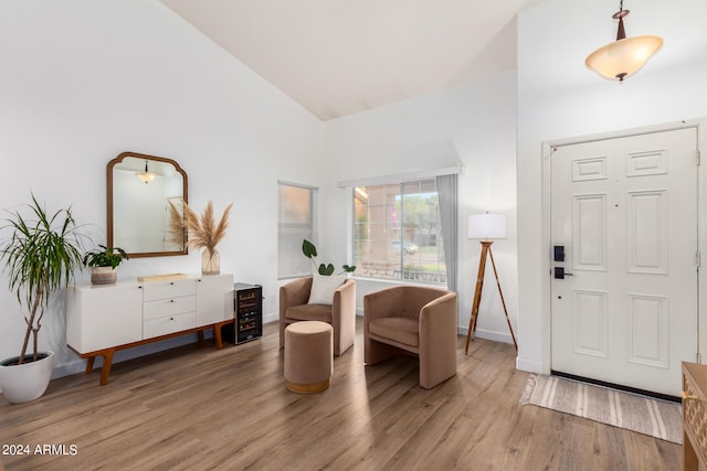 entrance foyer with light hardwood / wood-style floors and high vaulted ceiling