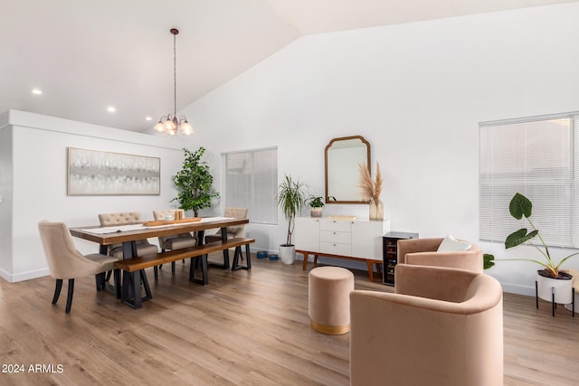 dining space with a chandelier, high vaulted ceiling, and light wood-type flooring