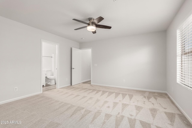 unfurnished bedroom with ceiling fan, light carpet, and ensuite bath