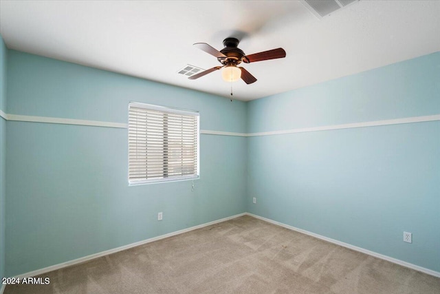 spare room featuring light colored carpet and ceiling fan