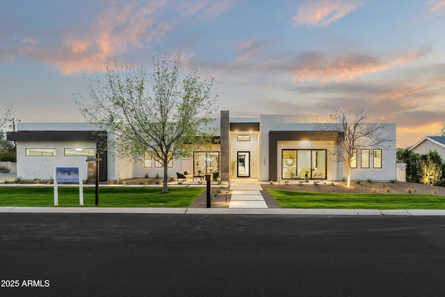 contemporary home featuring a front lawn and stucco siding