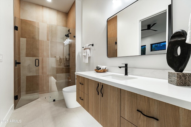 bathroom featuring vanity, a shower stall, toilet, and tile patterned floors