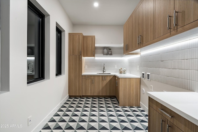 kitchen with decorative backsplash, tile patterned floors, light countertops, open shelves, and a sink