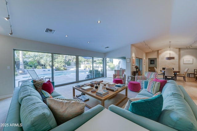 living room featuring vaulted ceiling and track lighting