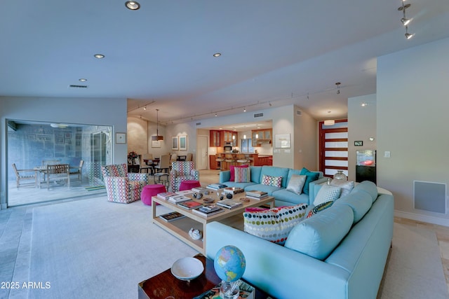 carpeted living room featuring rail lighting