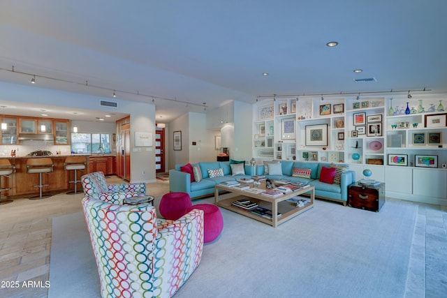 living room with sink, vaulted ceiling, and rail lighting