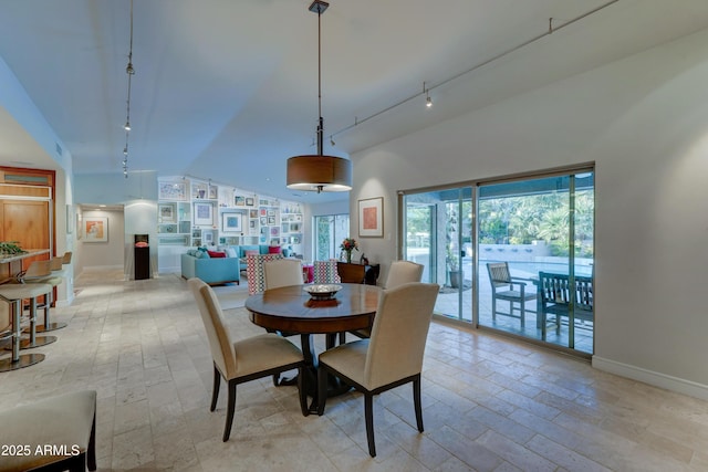 dining area featuring lofted ceiling and track lighting