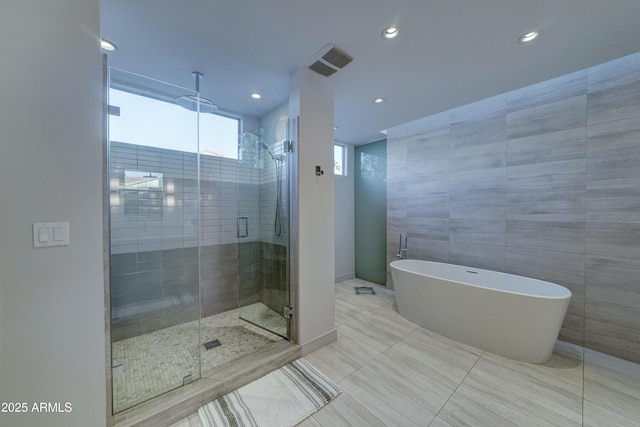 bathroom with independent shower and bath and tile walls